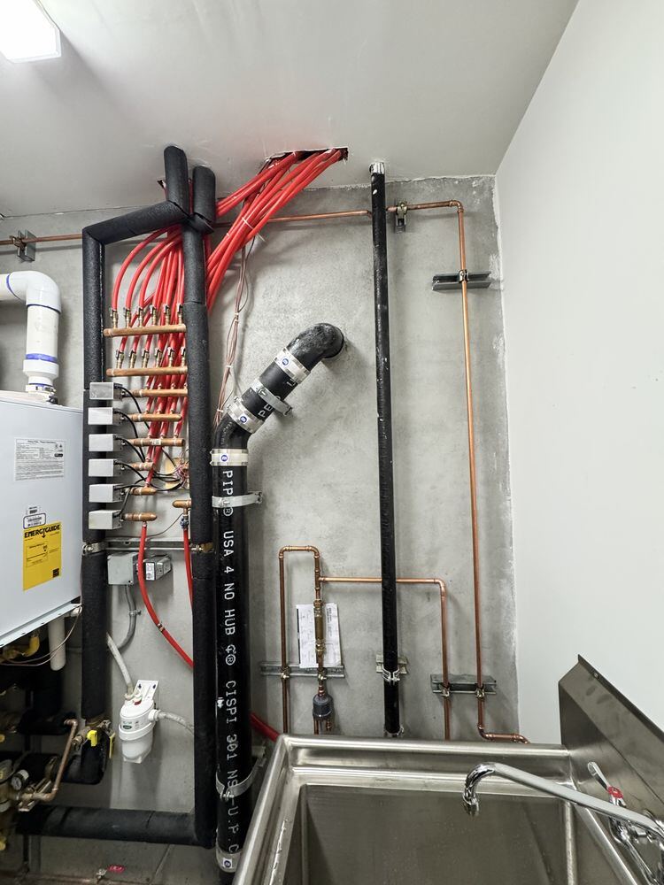 Tankless heater, PEX manifold, and cast iron stack in one room